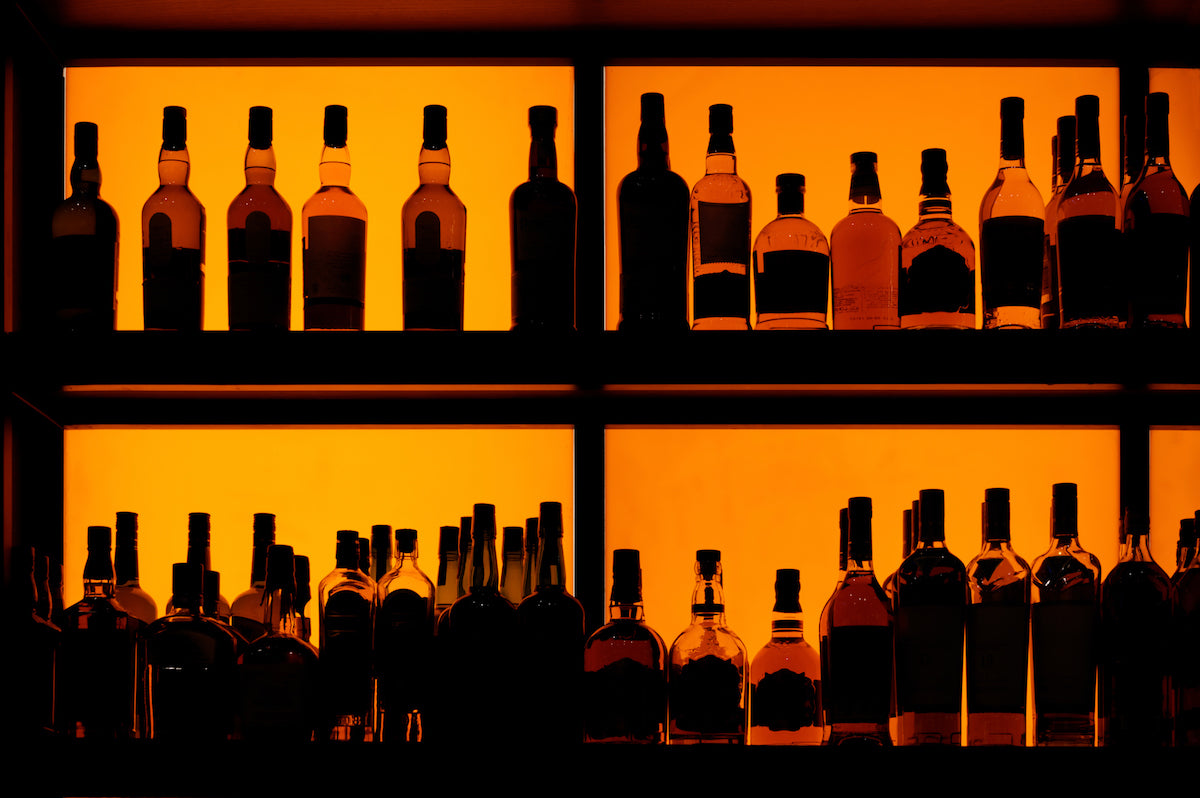 bottles of whisky behind a bar scotch in Japanese whisky